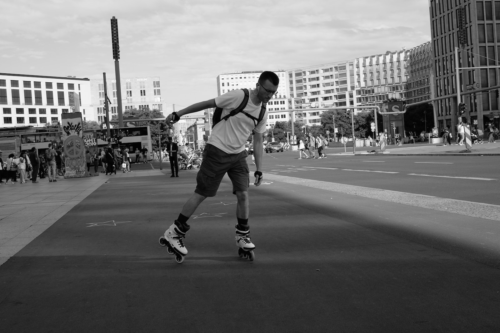grayscale photography of man riding inline skate