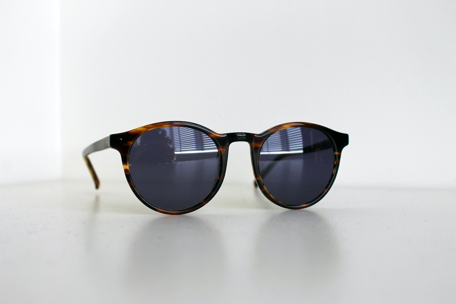 black framed sunglasses on white table